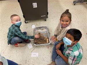 students smile with pride about the shelter they are building together